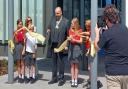 Cllr Stephen Ferguson is accompanied by pupils at Alconbury CoE Primary School to officially open New Shire Hall, Cambridgeshire County Council's headquarters.