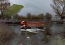 Vehicles navigating the flooded Sutton Gault Causeway.