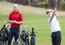 Alfie Edgson, watched by professional partner Luke Goddard, fires in a fine iron shot at Heacham Manor.