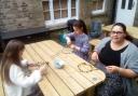 Children making floral crowns fit for a Rose Queen from artificial flowers on Saturday.