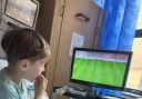 Hunter Martin, aged six, watches football in his hospital room