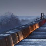 Rough seas batter Walcott as dawn breaks on the Norfolk coast as spring tides and winter weather combine to cause flood warnings. Simon Finlay Photography.