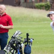 Alfie Edgson, watched by professional partner Luke Goddard, fires in a fine iron shot at Heacham Manor.