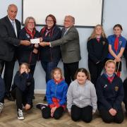 Guide leaders Marcia Whitehead and Natalie Taylor receiving a cheque from Wisbech Freemasons David Broker and Richard Smith, pictured with some of the guides.