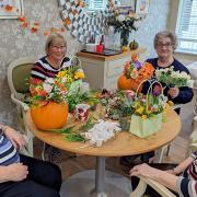 Residents and loved ones enjoying the pumpkin flower arranging session at Hickathrift House care home.